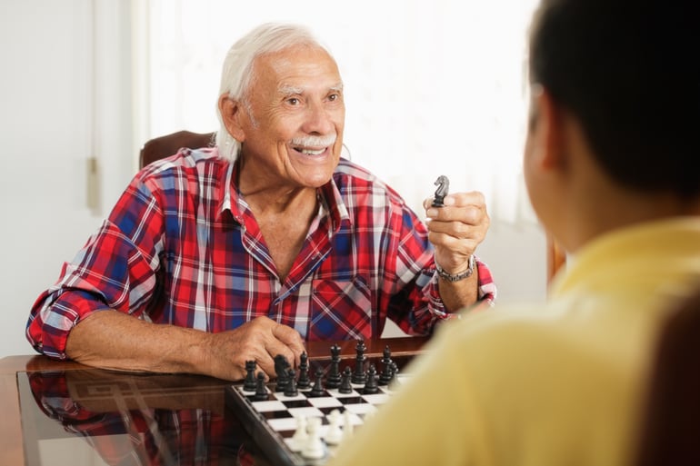 grandpa-playing-chess-board-game-with-grandson-at-PBXQVA9